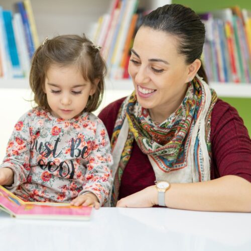 mom reading with preschooler daughter