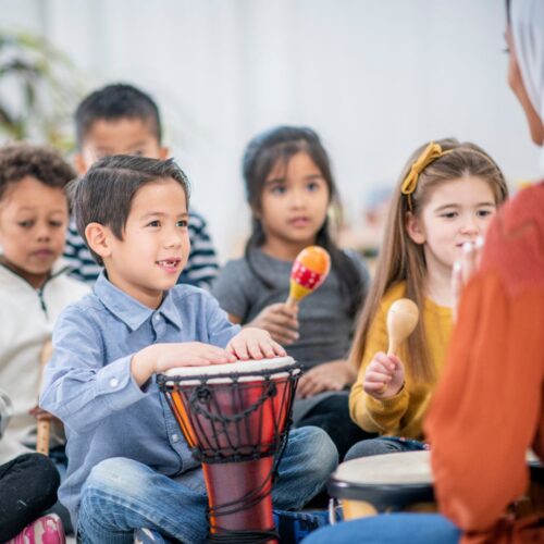 kids playing music with teacher