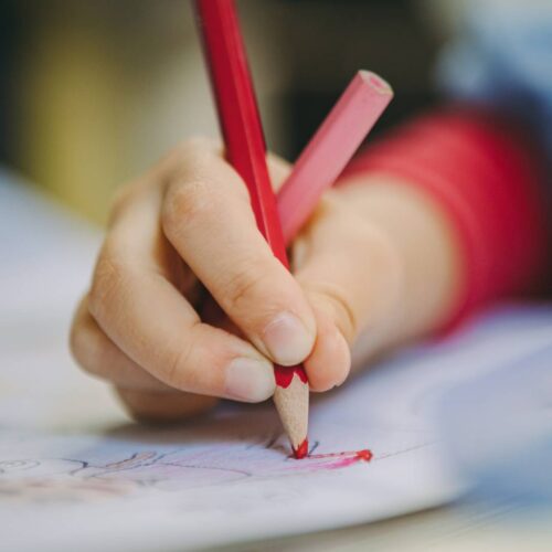 image of a kid using a pencil