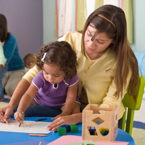 child care provider drawing with child