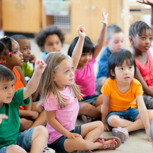 kids raising hands in preschool